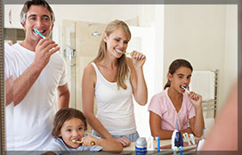 Family Brushing Teeth In Bathroom Mirror