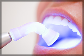 Dentist Performing Teeth Whitening to a Female Patient