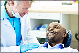 Dentist Talking To Smiling Male Patient Before Oral Surgery