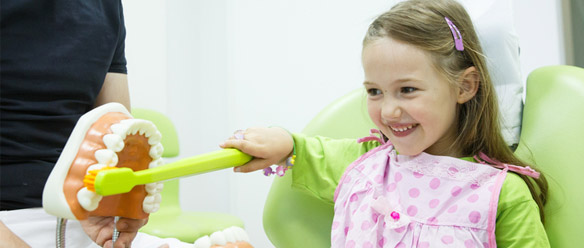 little girl learning to brush with fun at dentist's office in Ottawa