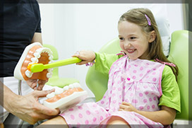 little girl learning to brush with fun at dentist's office in Ottawa
